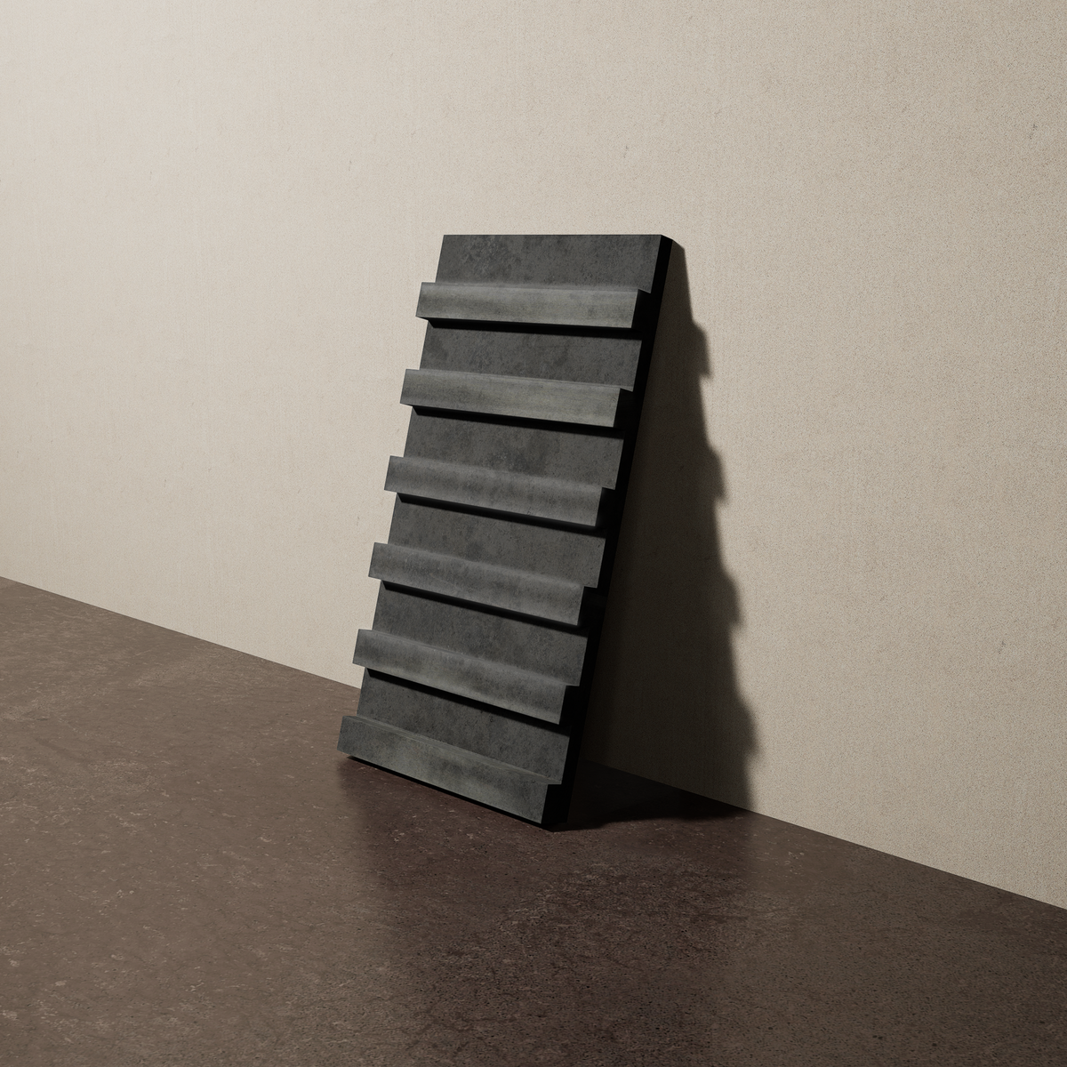 a 15"x8" bespoke dimensional concrete tile with six evenly spaced tiers leans against a textured, plaster wall on an unfinished concrete floor